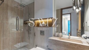 Ein modernes Badezimmer mit einer Duschkabine, einem Waschtisch mit Spiegel und einer Toilette.