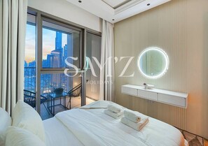 A hotel room with a large bed, a vanity with a mirror, and a balcony with a city view. - Stylish 2BR in Downtown Views - High Floor 2906 (Dubai)