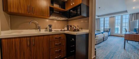 A modern kitchen with wooden cabinets, a microwave, and a coffee maker.