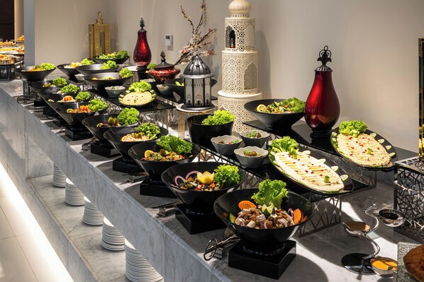 A buffet with various dishes and a decorative white lantern.