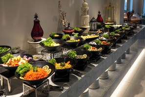 Een buffet met verschillende gerechten, een decoratieve lantaarn en een hoge, torenachtige constructie.