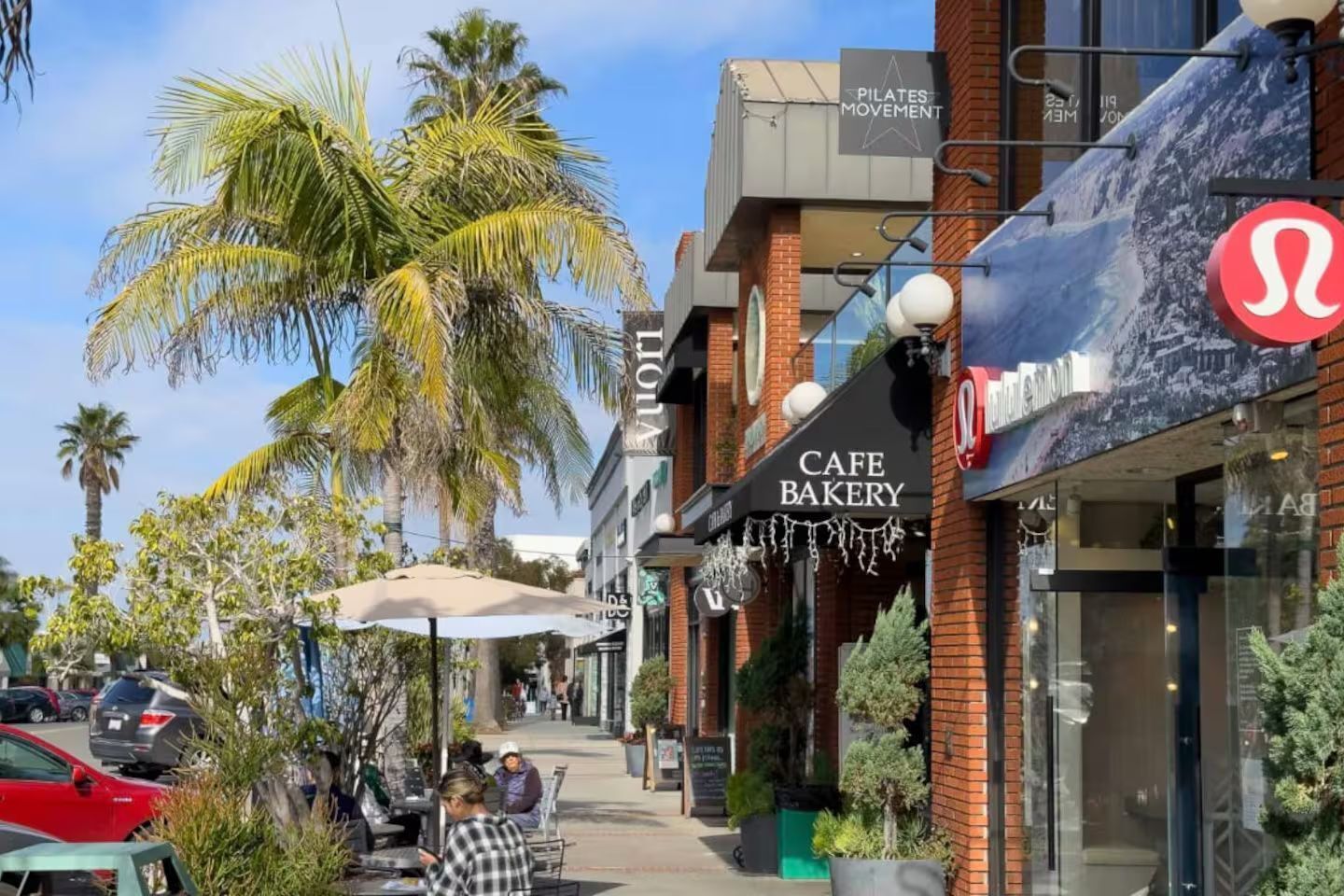 A street with a cafe bakery, a pilates studio, and a restaurant.