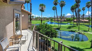 A balcony with outdoor furniture, a view of a golf course, and a body of water. - Exclusive 2BR, Golf Views & Private BBQ (Palm Desert)