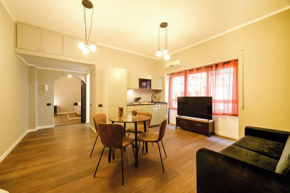 Un salon moderne comprenant un coin repas, un téléviseur à écran plat et un canapé.