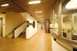 Ein sauberes, modernes Interieur mit Treppe, einer Rezeption und einer Glaswand.