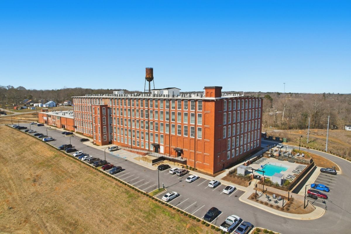 A large brick building with a parking lot and a swimming pool.