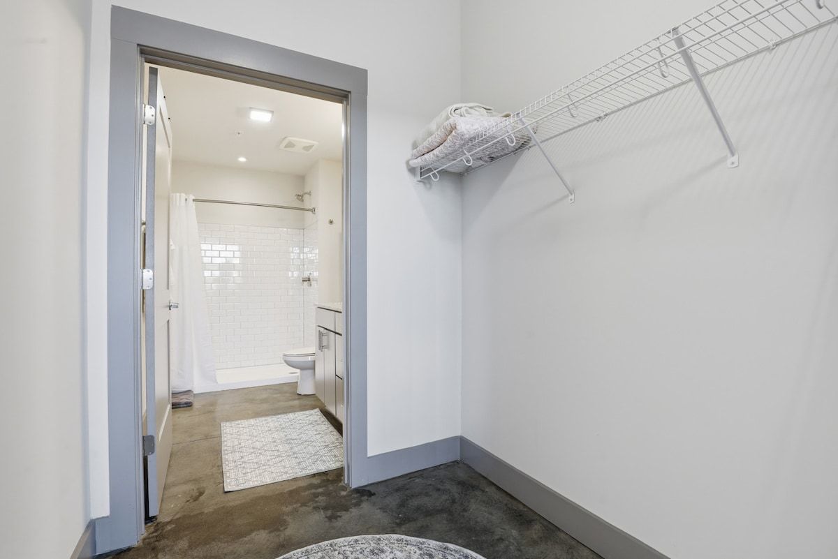 A bathroom with a shower, toilet, and a towel rack.