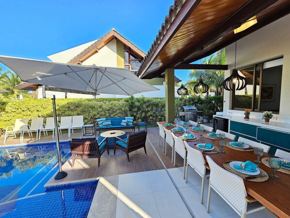 An outdoor patio area with a pool, dining table set for six, and a barbecue grill. - Bangalo com Piscina Privativa no Malawi Beach Porto de Galinhas (Ipojuca)