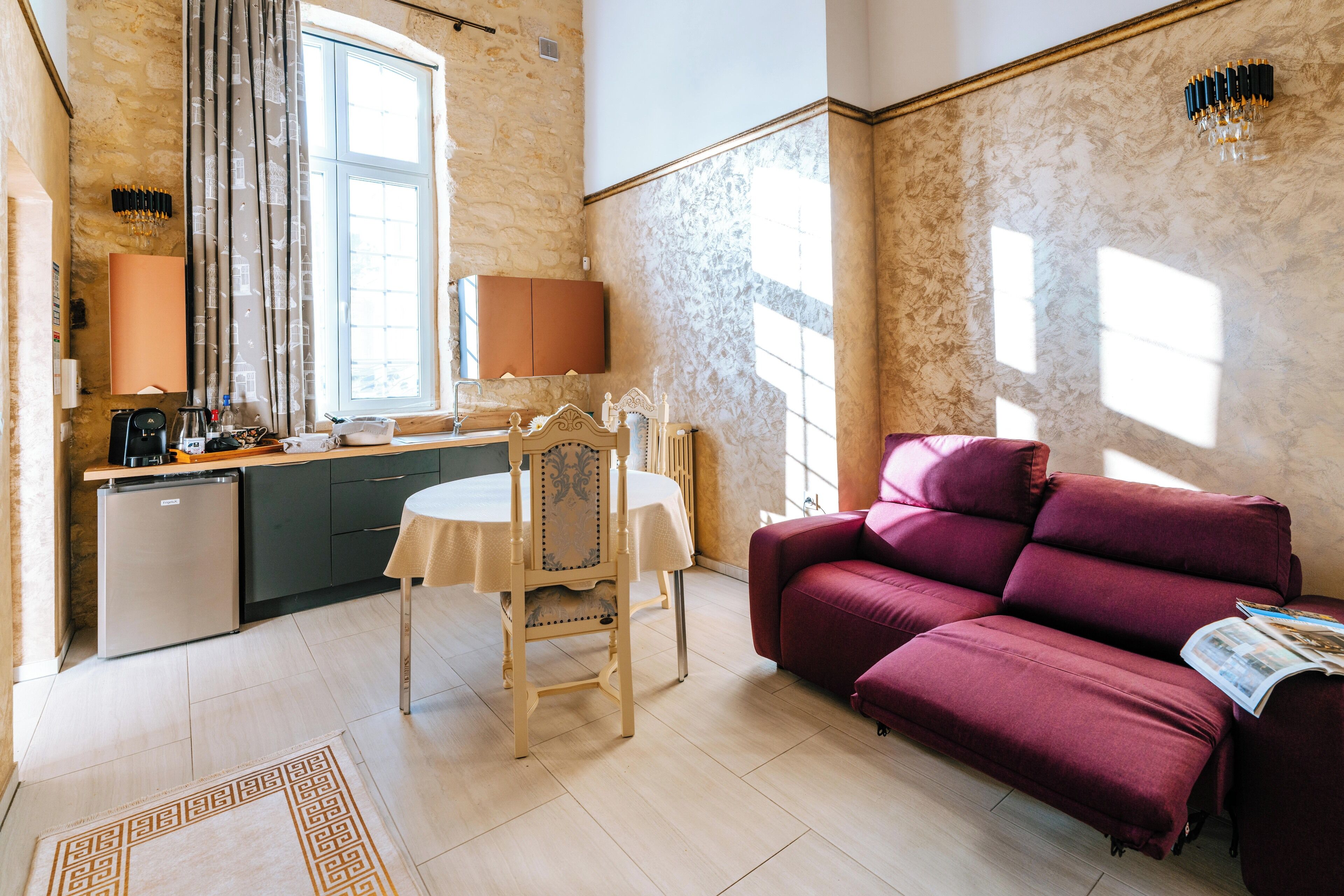 A compact living space with a dining area, a sofa, and a kitchen.