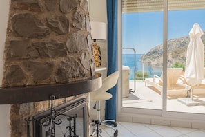 A stone wall, a white chair, a view of the sea, and a balcony with a white umbrella. - Frontline Mediterranean Villa • Heated Pool & Jacuzzi • 3m Walk to Beach & Port (Calp)