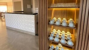 Et moderne hotelreceptionsområde med en receptionsdisk og et udstilling af teposer.
