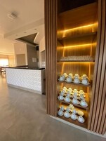Uma área de recepção de hotel com design moderno, com um balcão de atendimento e uma exposição de jogos de chá.