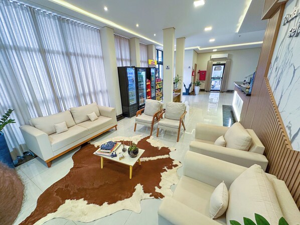 Un salon moderne avec un canapé, des fauteuils, une table basse et un tapis en peau de vache.