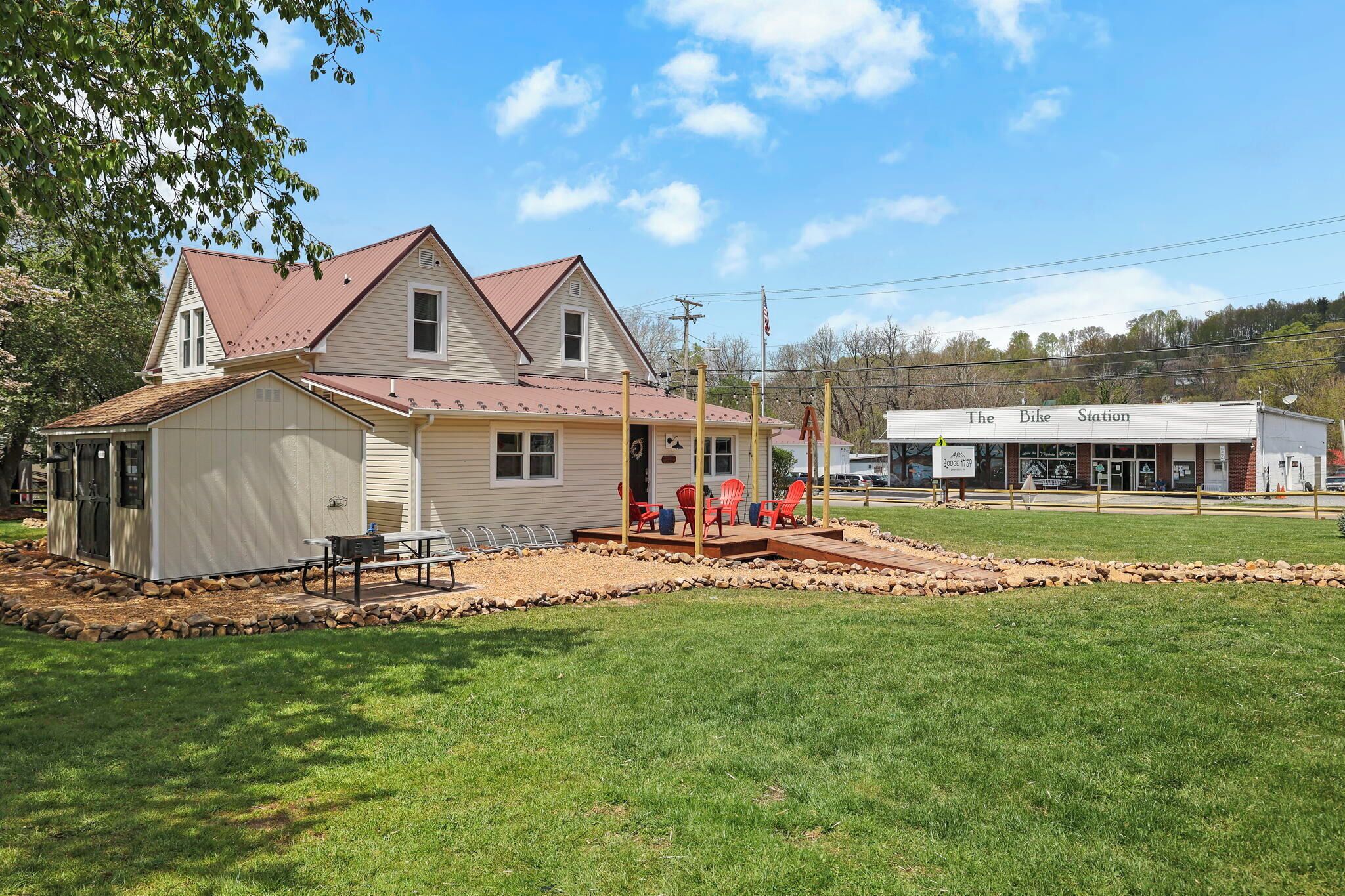 A two-story house with a porch and outdoor seating area.