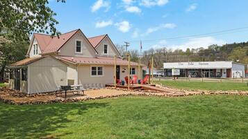 A two-story house with a porch and outdoor seating area.