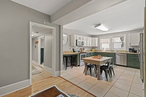 Une cuisine moderne dotée d’un îlot central, d’appareils électroménagers intégrés et de nombreux plans de travail.