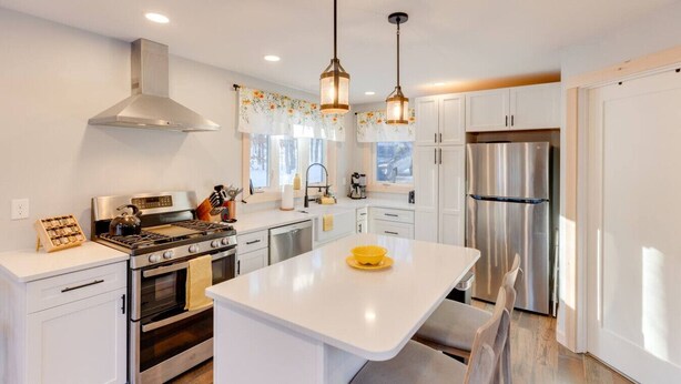 A modern kitchen with white cabinetry, stainless steel appliances, a central island, and pendant lighting. - Waterville Estates- Tons of Amenities! (Campton)