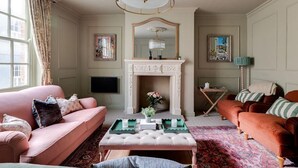 Una sala de estar con chimenea, dos sofás, una mesa de centro y un televisor.