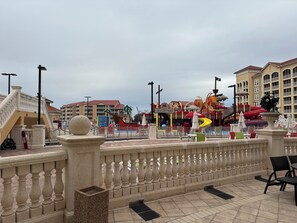 A water park with slides and a pool area, surrounded by buildings with balconies.