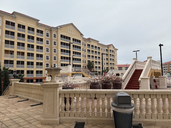 A multi-story hotel with balconies, a fountain, and a staircase.