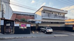 A motel with a sign advertising a 3-hour stay for R$ 64.90. - Motel Fascinação (Contagem)
