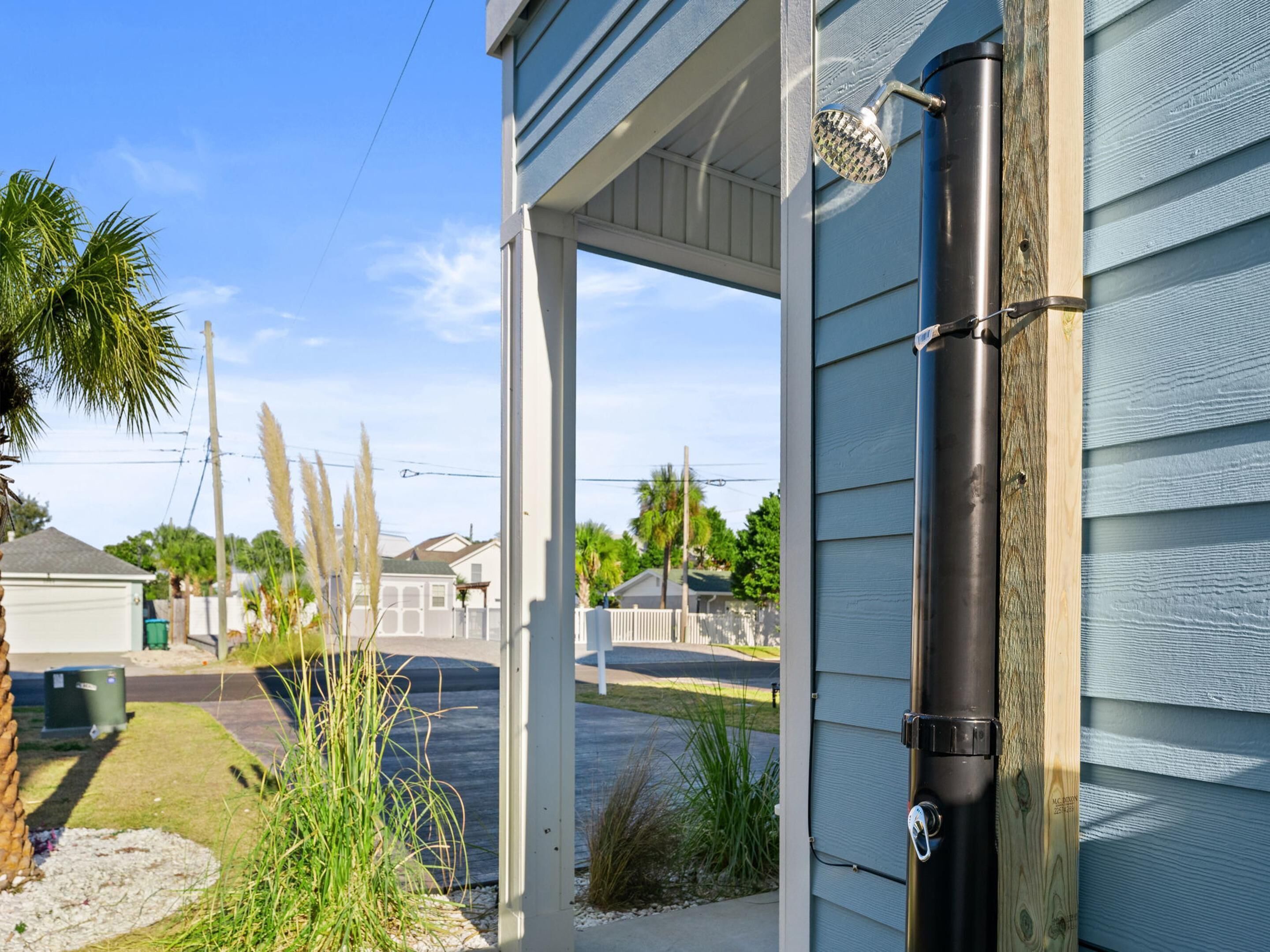 A house with a garage door, a wooden post, and a metal pipe.