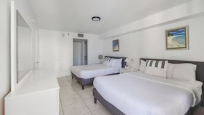 A hotel room with two beds, a desk, and a painting on the wall. - Brickell Bay 3304 (Miami)