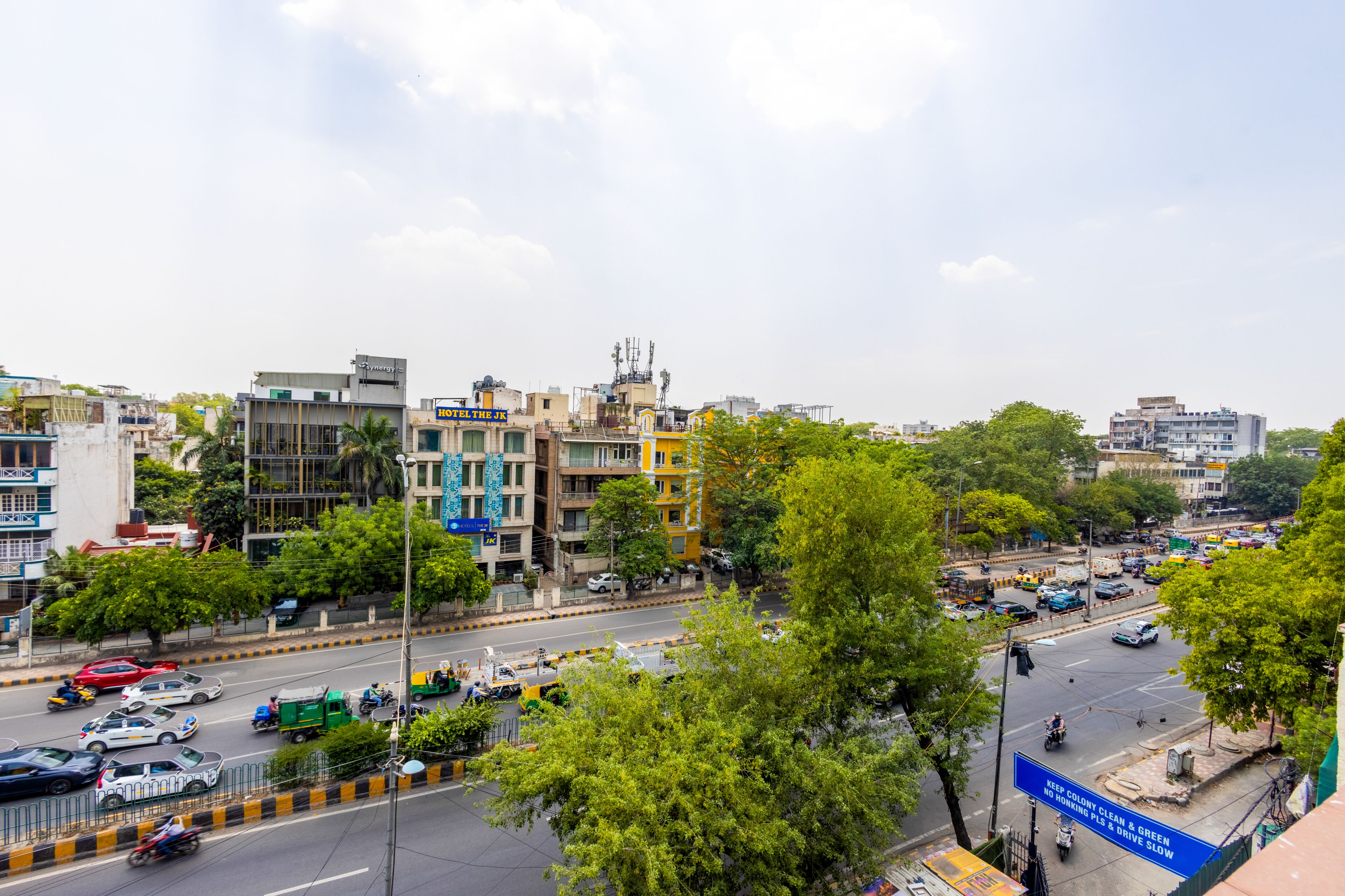 A busy urban street with buildings, vehicles, and trees.