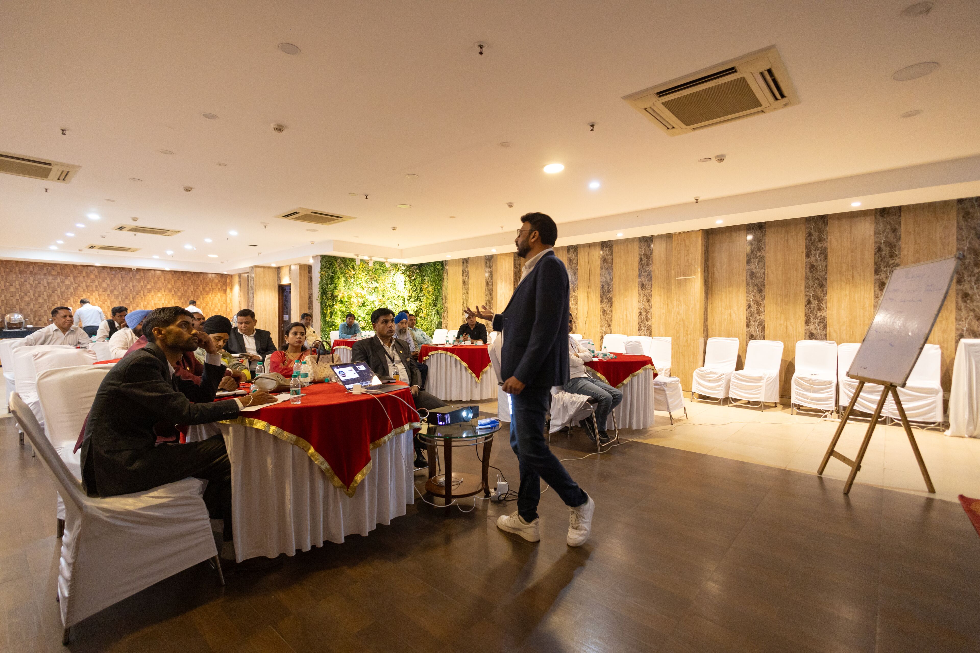 A conference room with round tables, chairs, and a whiteboard.