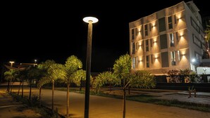 A modern building with multiple windows and a well-lit facade at night.
