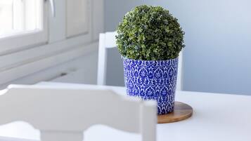 Een potplant op een houten onderzetter op een witte tafel.