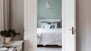 Un dormitorio con una cama, una lámpara colgante y una planta en maceta.