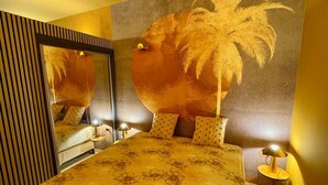 Una camera da letto con un letto grande, uno specchio e una parete con il motivo di una palma.