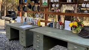 A rustic outdoor kitchen with a workbench, cooking utensils, and a grill. - Emerson Camp, Private Glamping Radio Ranch (Tub) (Burnt Ranch)