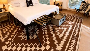 A tented accommodation with a bed, a hanging light fixture, a chair, and a patterned rug. - Emerson Camp, Private Glamping Radio Ranch (Tub) (Burnt Ranch)