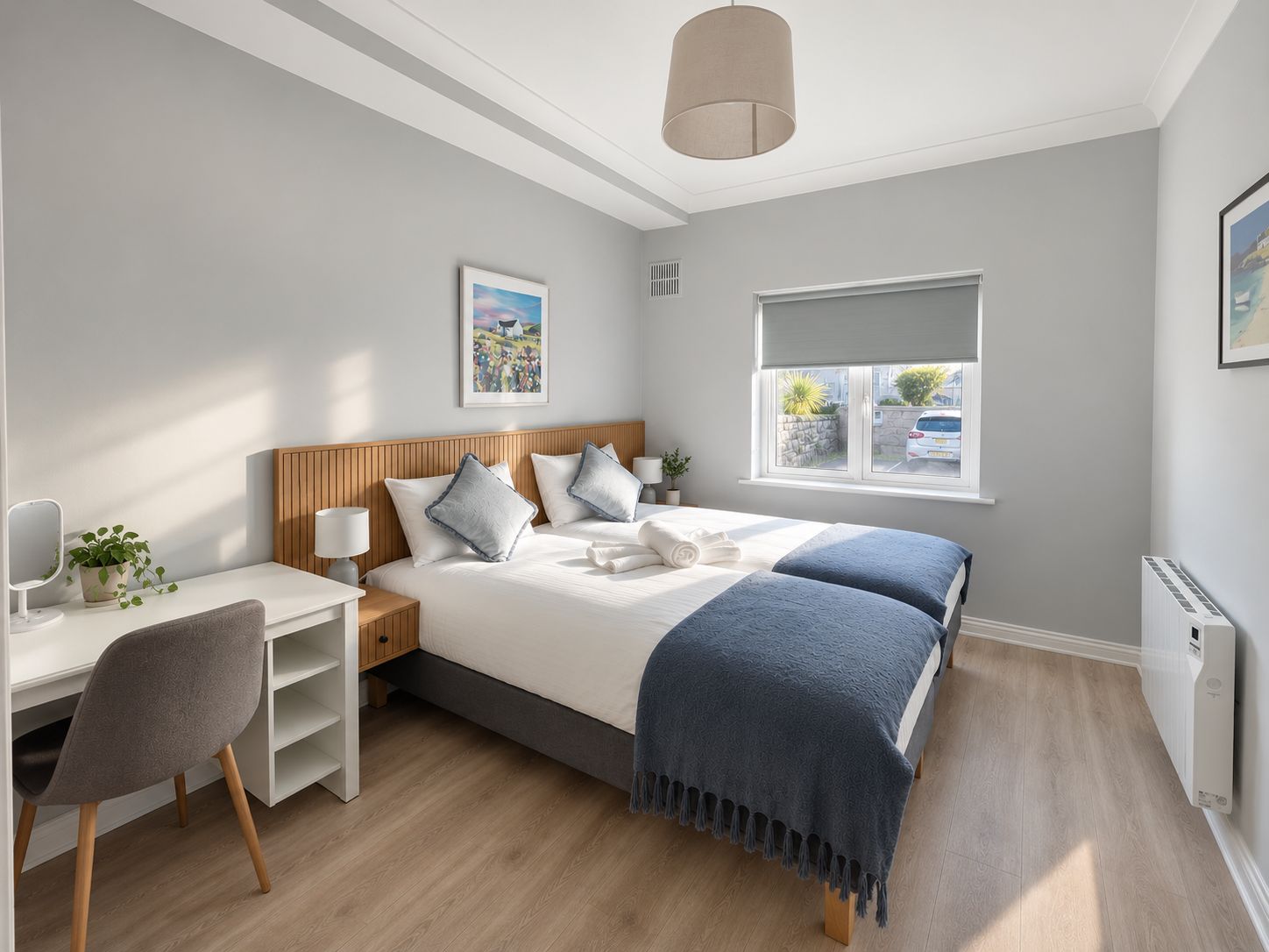 A modern bedroom with a bed, bedside tables, a desk, and a chair.
