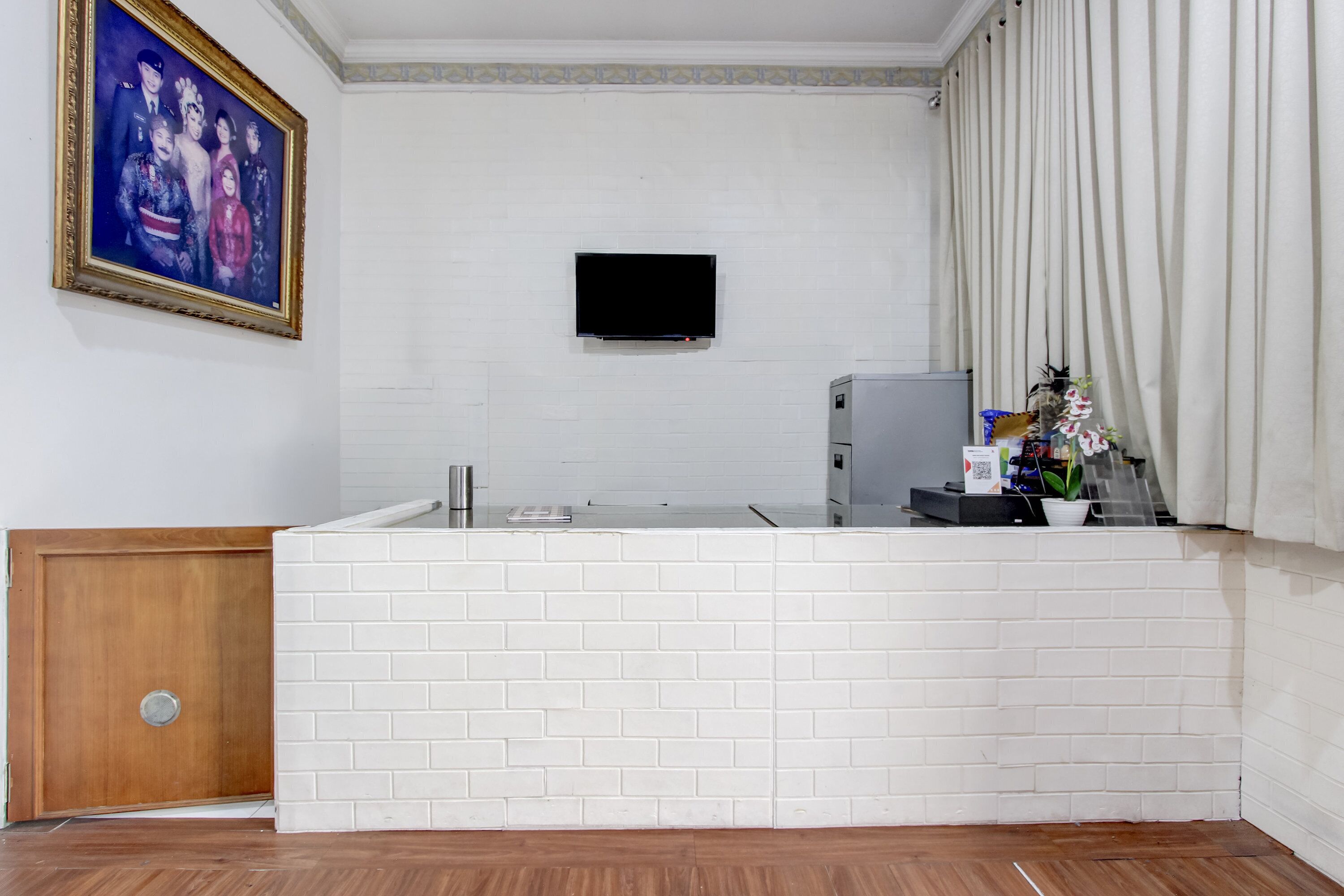 A modern kitchen with a white brick backsplash, a built-in refrigerator, and a flat-screen TV mounted on the wall.