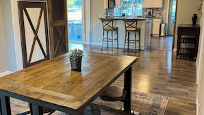A spacious kitchen with a central island, wooden flooring, and a large dining table with chairs. - Peaceful-Cozy Home!
Modern Touches & Outdoor
Space! (Buckley)