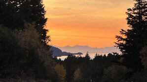 A road curving through a forest with a sunset in the background. - Resurrection Campsite #2 (Hope)