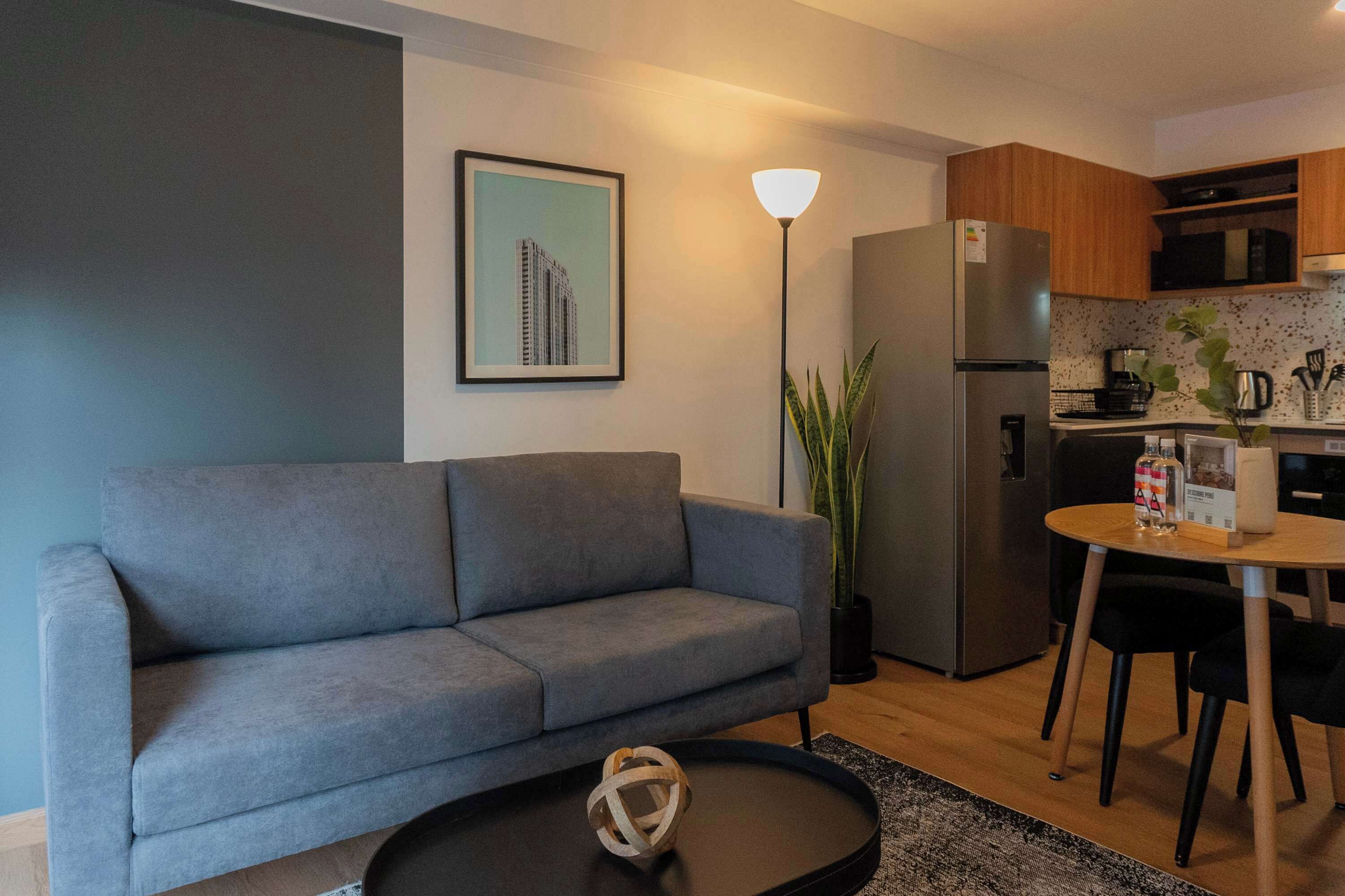 A modern living room with a grey sofa, a round coffee table, and a floor lamp.
