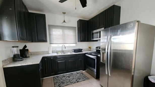 A modern kitchen with dark cabinets, stainless steel appliances, and a tiled floor. - Cozy 1-bedroom house in perfect Historical New Castle (New Castle)