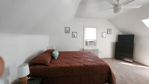 A bedroom with a bed, a nightstand, a lamp, a dresser, a ceiling fan, and a window. - Cozy 1-bedroom house in perfect Historical New Castle (New Castle)
