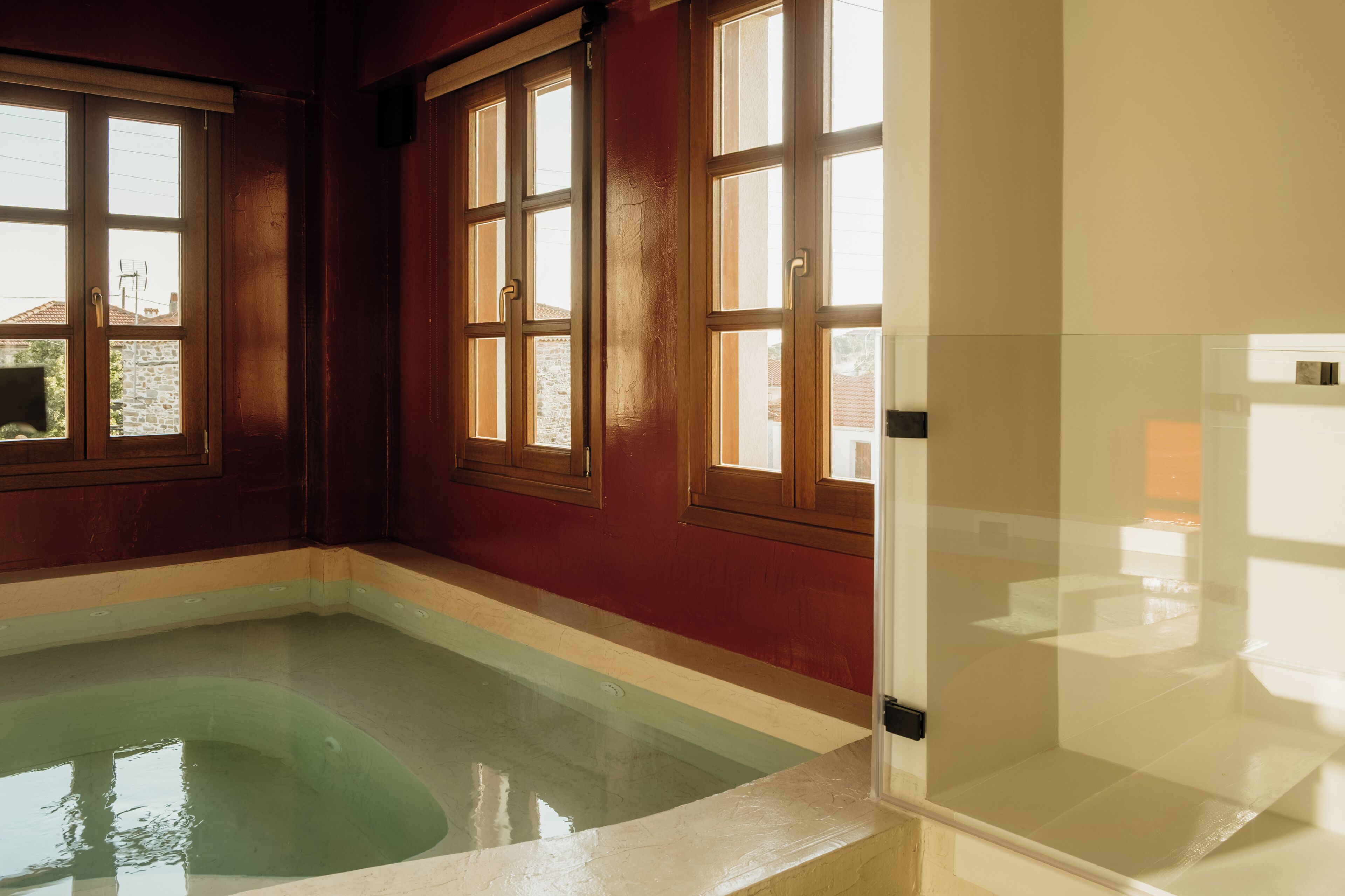 Une pièce avec une piscine, de grandes fenêtres et une porte.