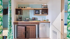 Eine kleine Küche mit einer Mikrowelle, einem kleinen Kühlschrank und einer Kaffeemaschine.