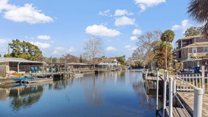 Une rivière paisible, bordée de quais et de bateaux, et entourée de bâtiments résidentiels et d’arbres.