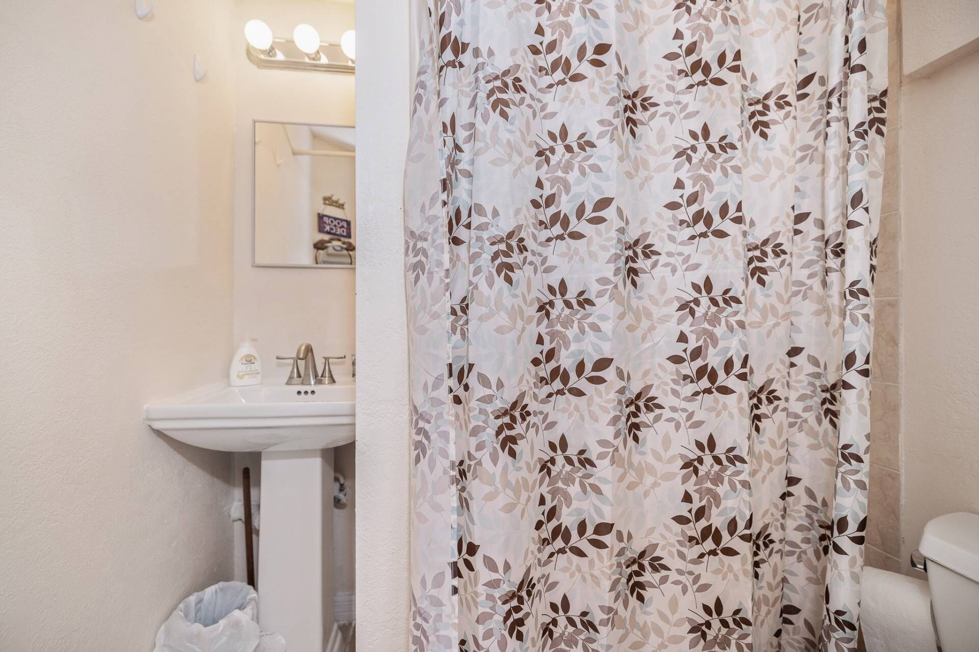 Une salle de bain avec un lavabo, un miroir et des toilettes.