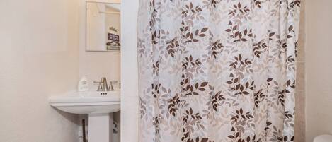 Une salle de bain avec un lavabo, un miroir et des toilettes.