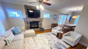 Una sala de estar con chimenea, televisor y comedor.