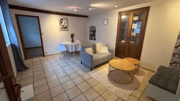 A living room with a sofa, a dining table, and a small coffee table.
