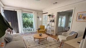 Un salon comprenant un canapé, un fauteuil, une table basse et une bibliothèque.